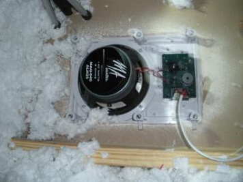 Picture from the attic of a MA Audio speaker system securely attached to the attic drywalll with speaker wires connected