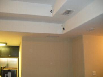 Picture of the installed left rear surround speaker installed and completed in the ceiling with the speaker grill attached